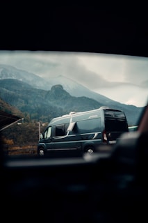 A comfortable van parked at a picturesque mountain landscape.