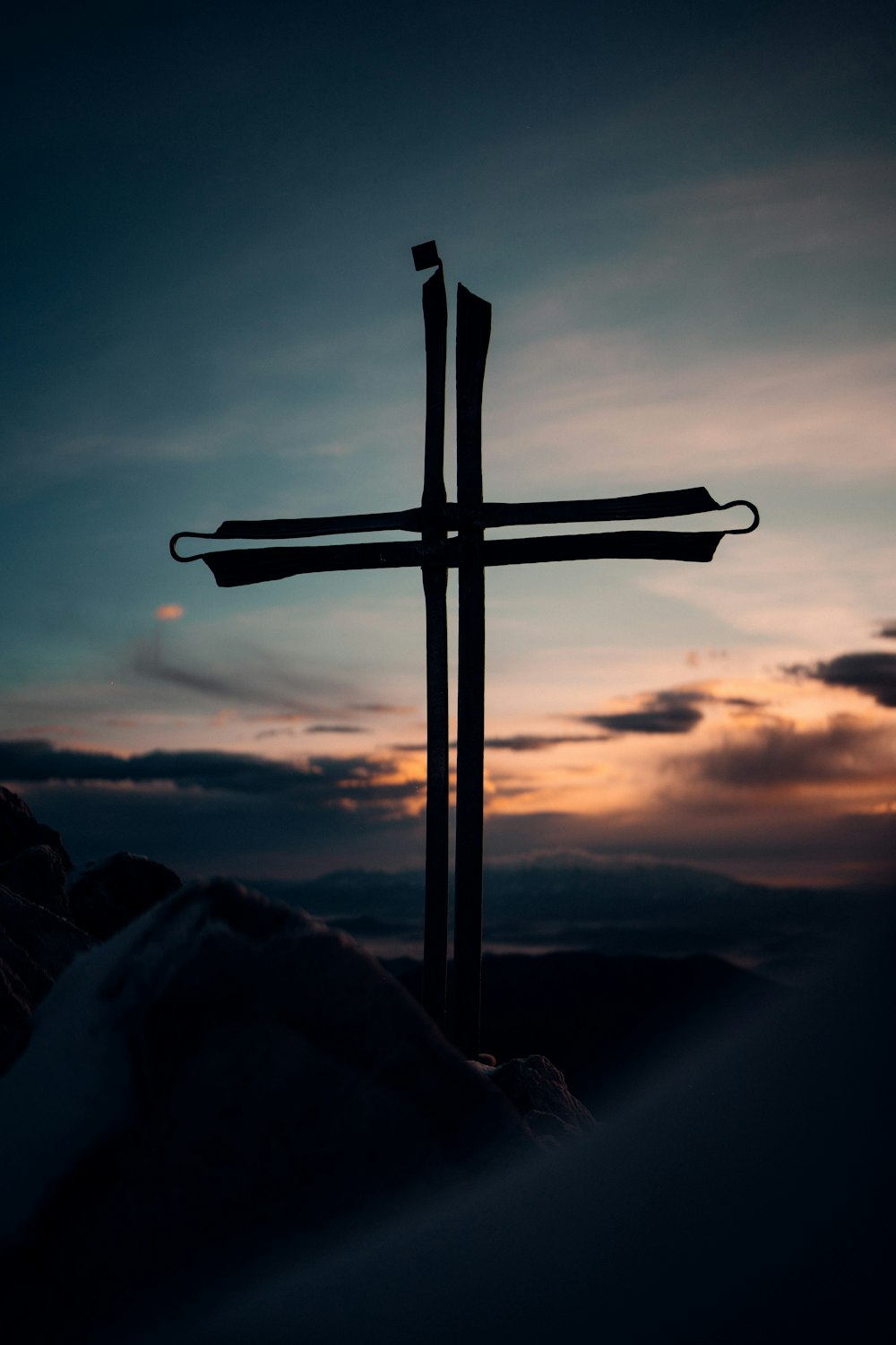 a cross on top of a mountain with a sky background