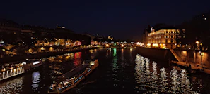 Nighttime shot of the Seine River reflecting city lights and passing boats