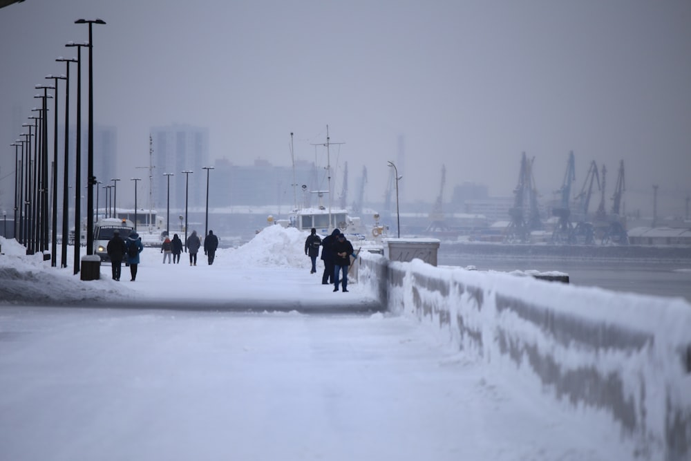 a group of people walking across a snow covered bridge