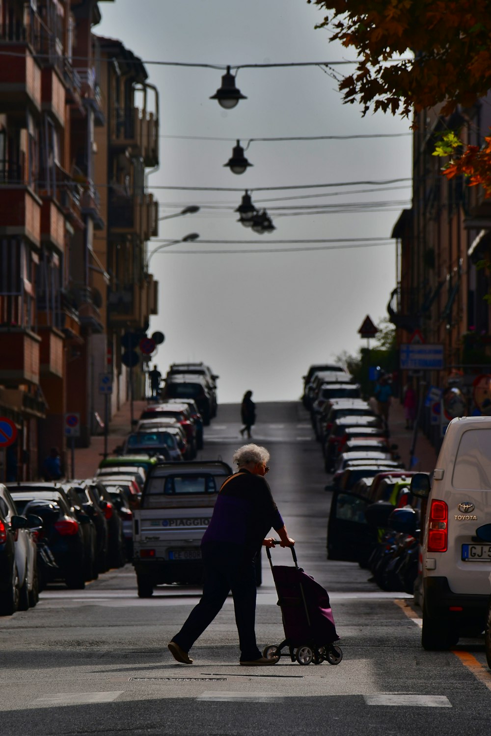 a woman walking down a street holding a suitcase