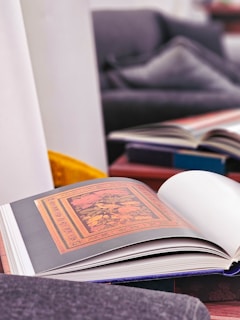 The art book opened to a vibrant, detailed illustration page with rich colors and intricate designs.