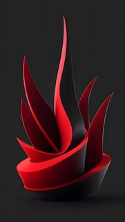A modern abstract sculpture featuring sharp, flowing shapes and curves with a sleek design. The structure primarily uses a bold red and black color scheme, creating a striking contrast against a dark background. The composition suggests movement and dynamism, with a smooth, polished surface.