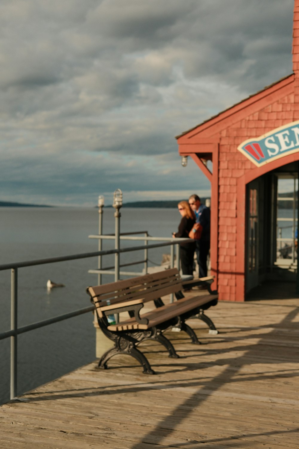 a couple of benches sitting on top of a wooden pier