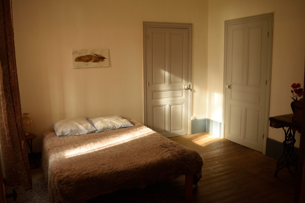 a bed sitting in a bedroom next to two doors