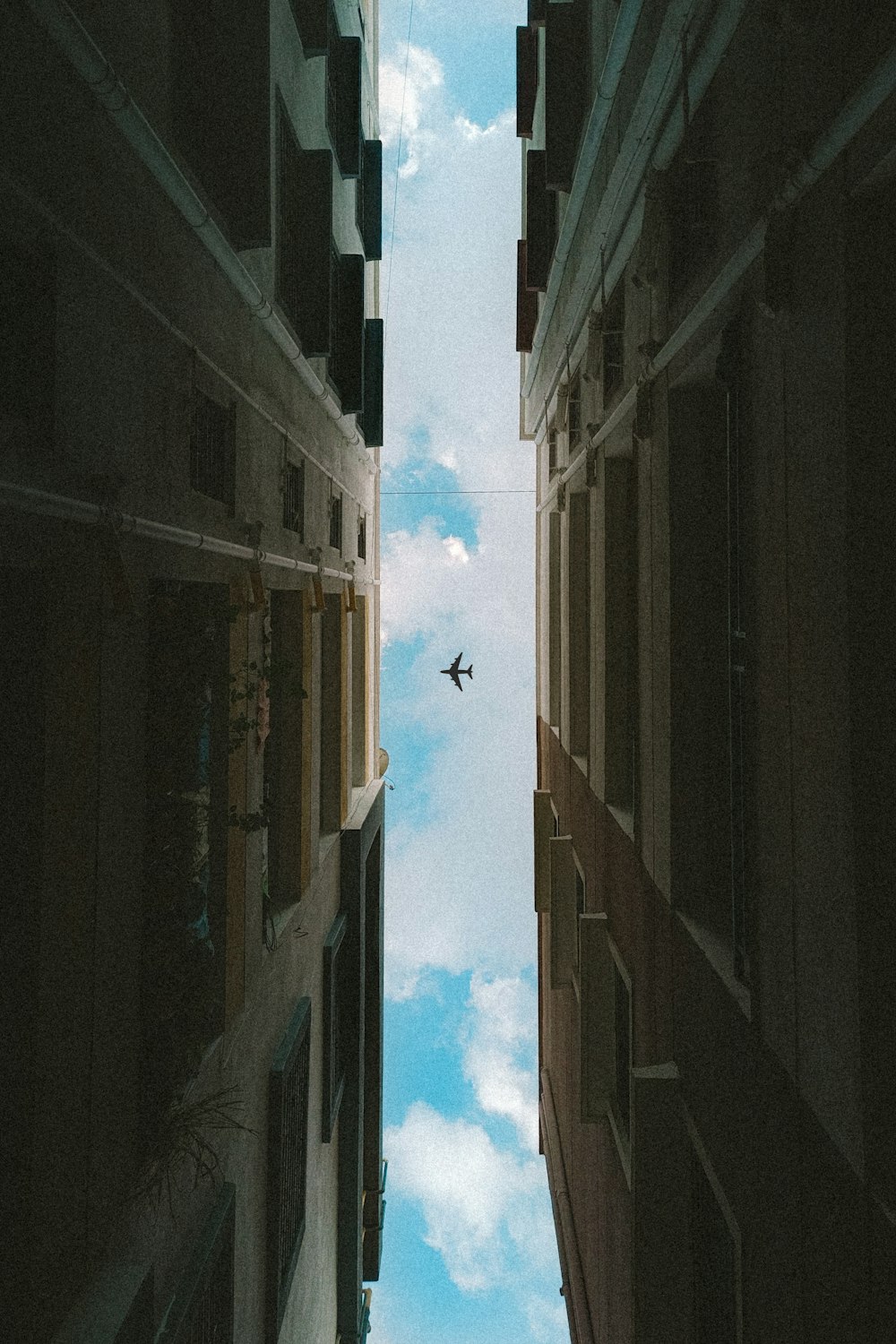 an airplane flying through the sky between two buildings