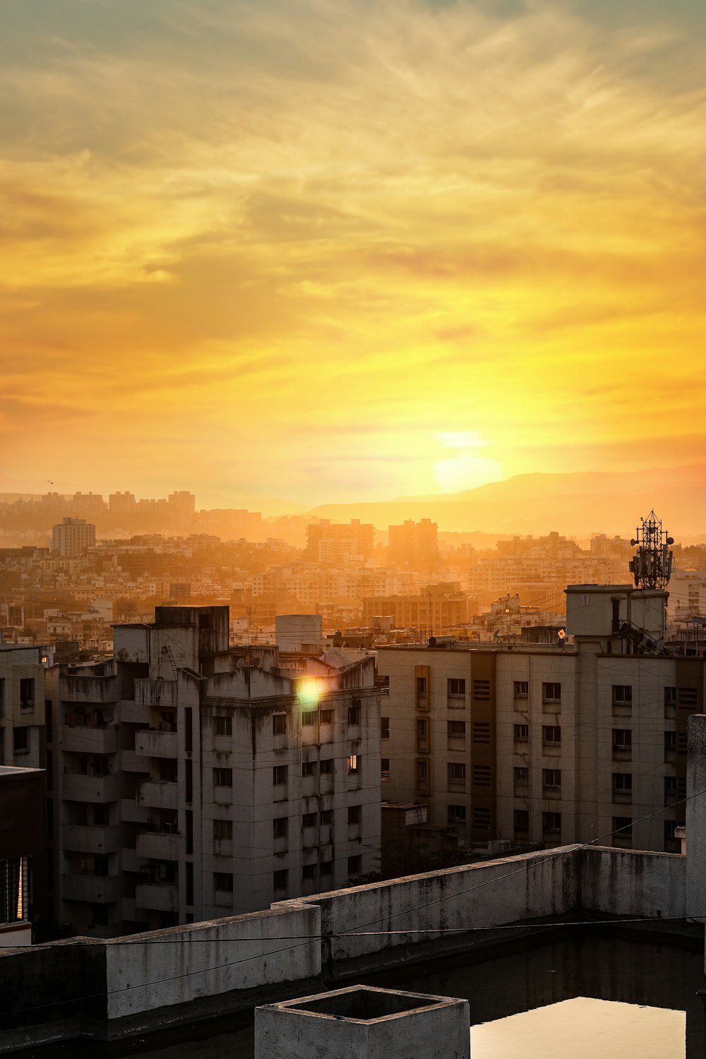 the sun is setting over a city with tall buildings