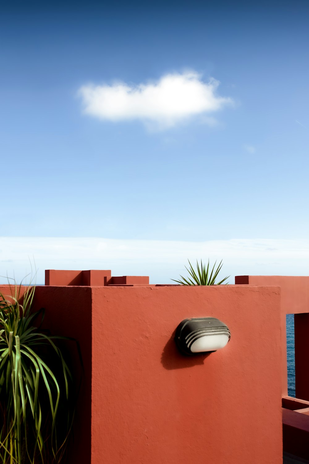 a red building with a white cloud in the sky