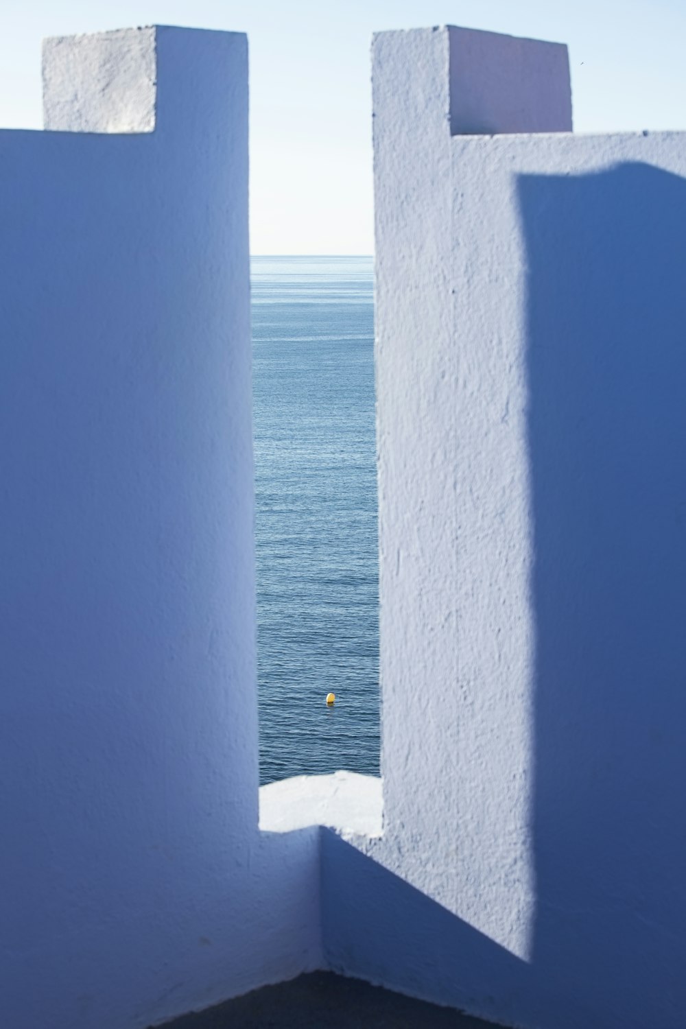 a view of the ocean through two white walls