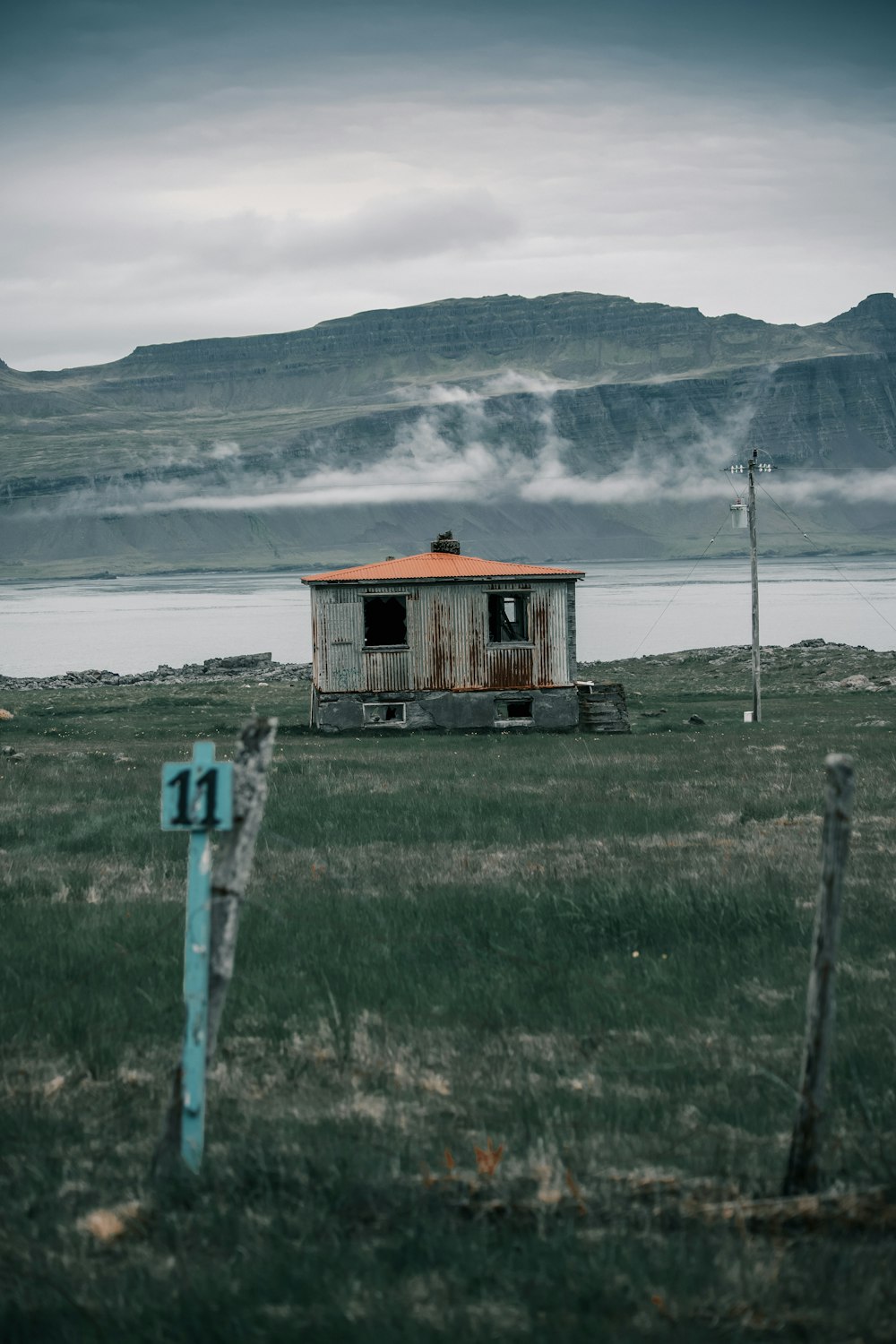 a small shack sitting on top of a lush green field