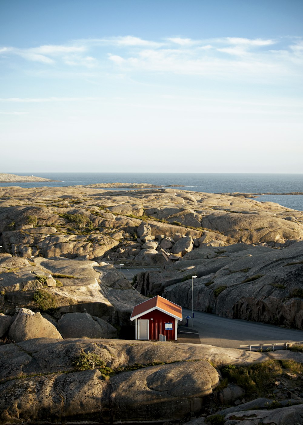 a small red building sitting on top of a rocky hillside