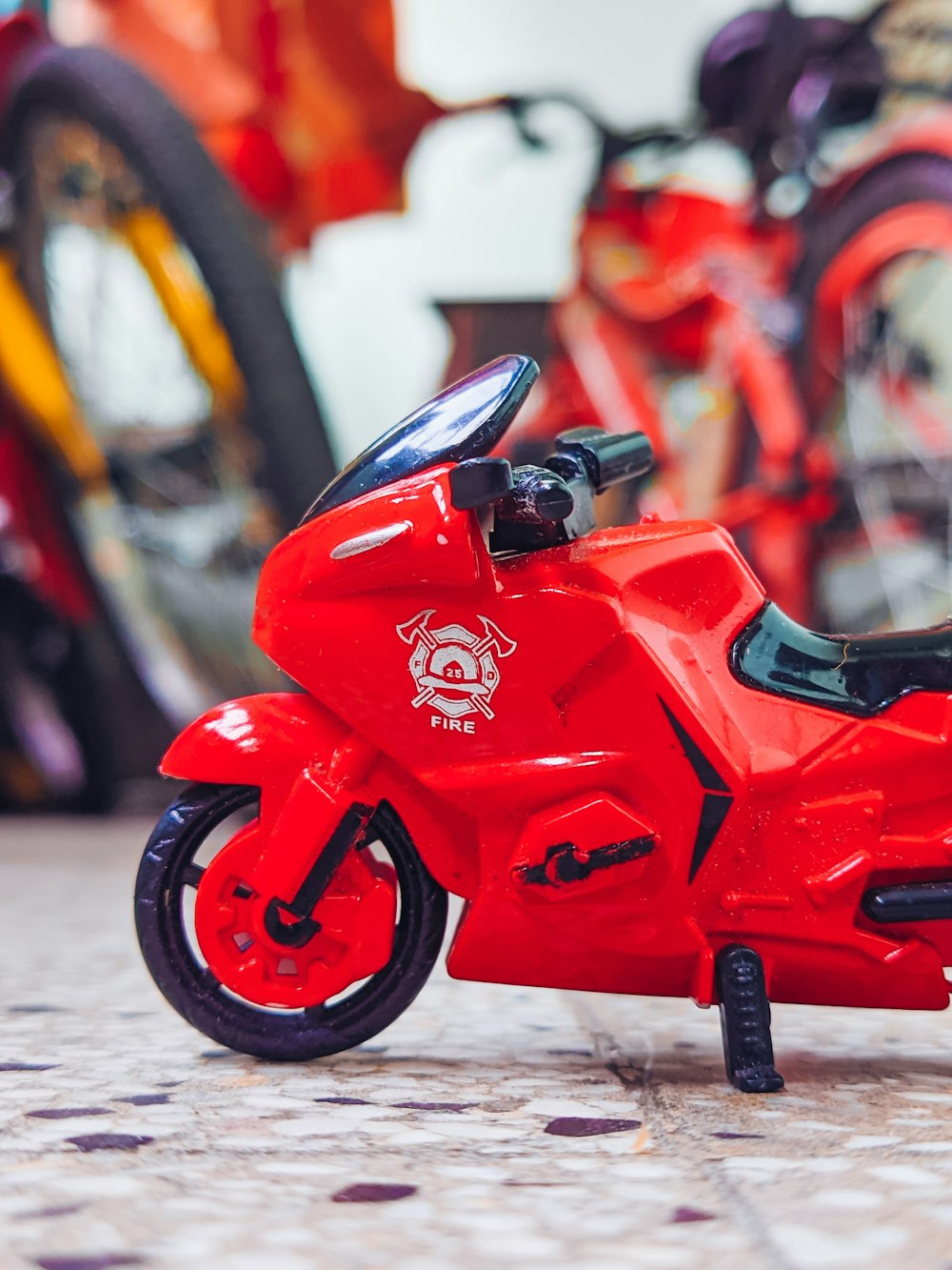 a red toy motorcycle sitting on top of a tile floor
