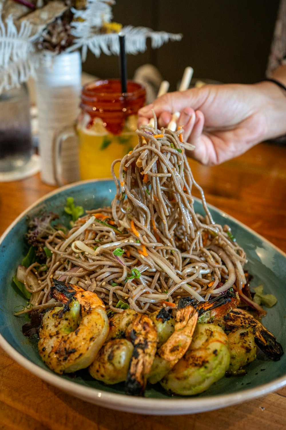 a bowl of noodles with shrimp and vegetables