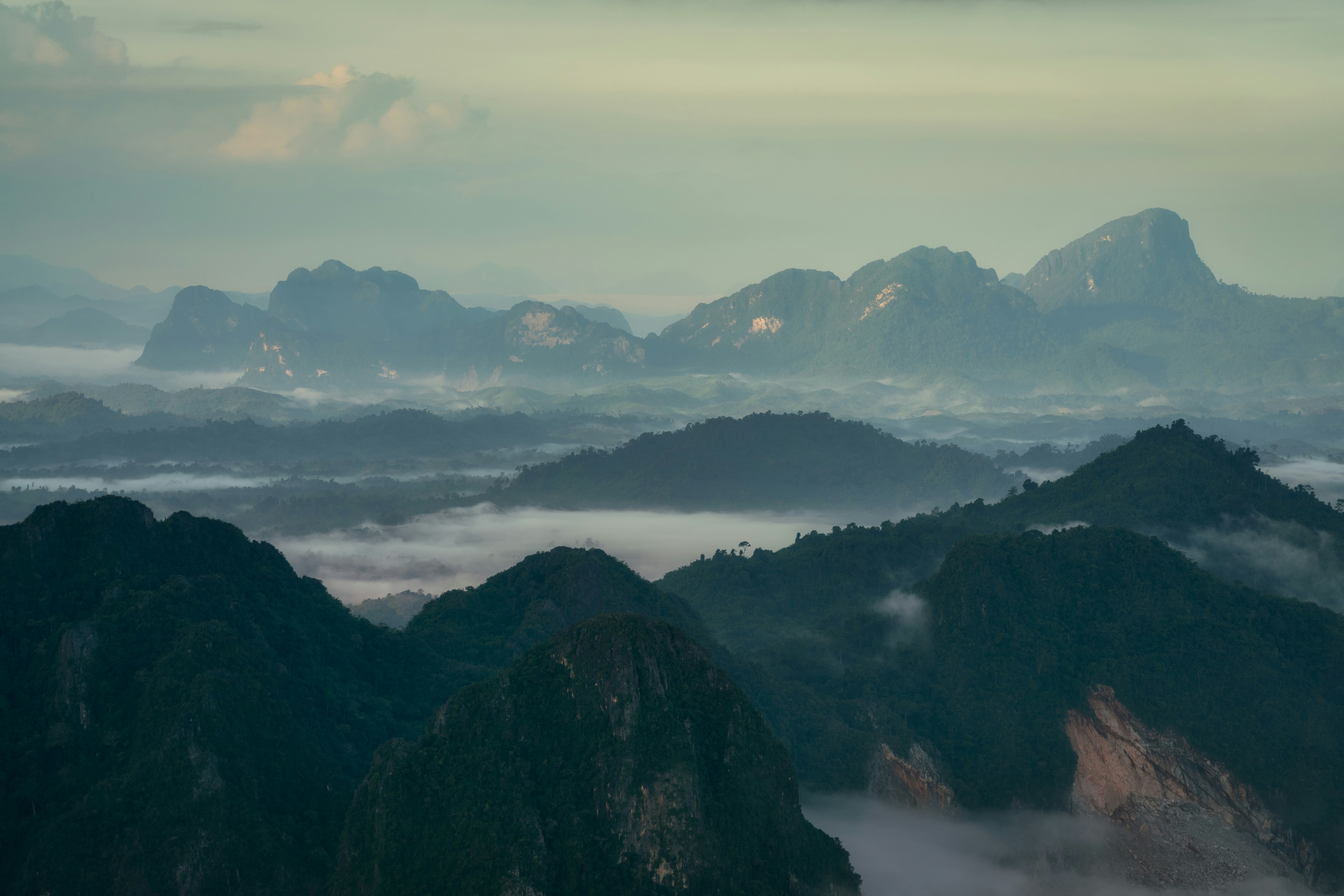 a view of a mountain range covered in fog