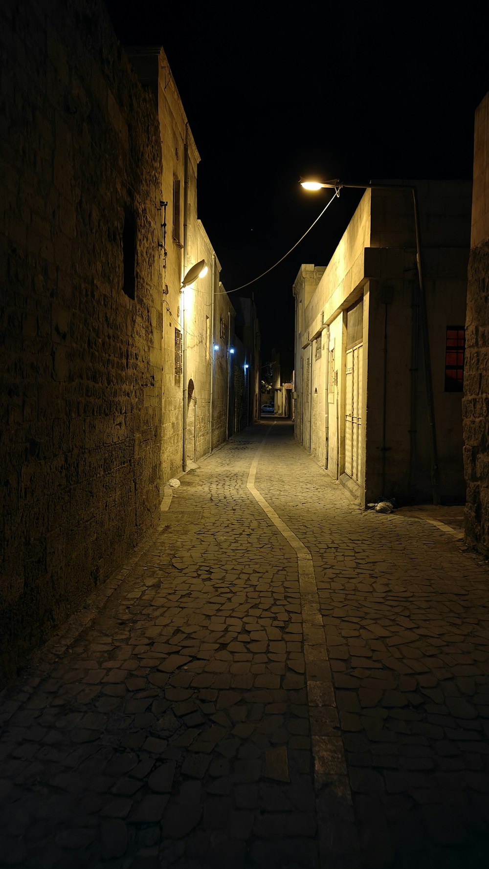 a dark alley way with cobblestones at night
