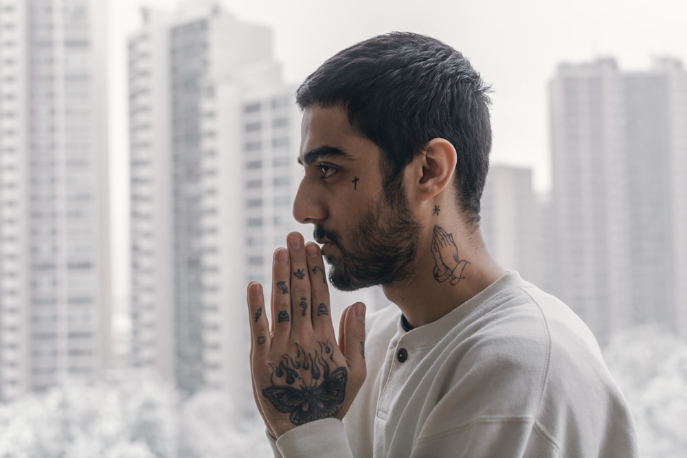 a man with tattoos on his face and hands