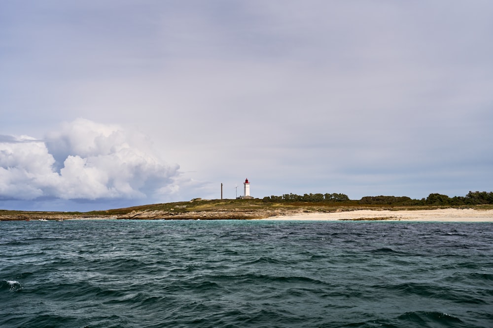 a lighthouse on a small island in the middle of the ocean