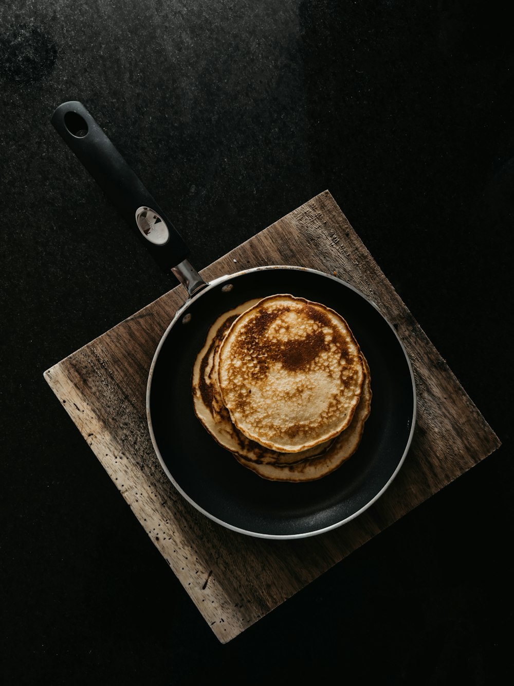 a pancake sitting on top of a wooden cutting board