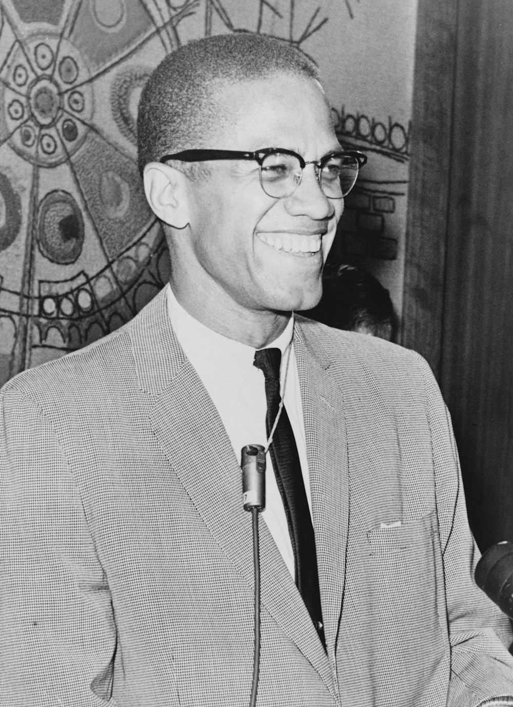 Malcolm X, Halbfigurenporträt, mit dem Gesicht nach rechts.