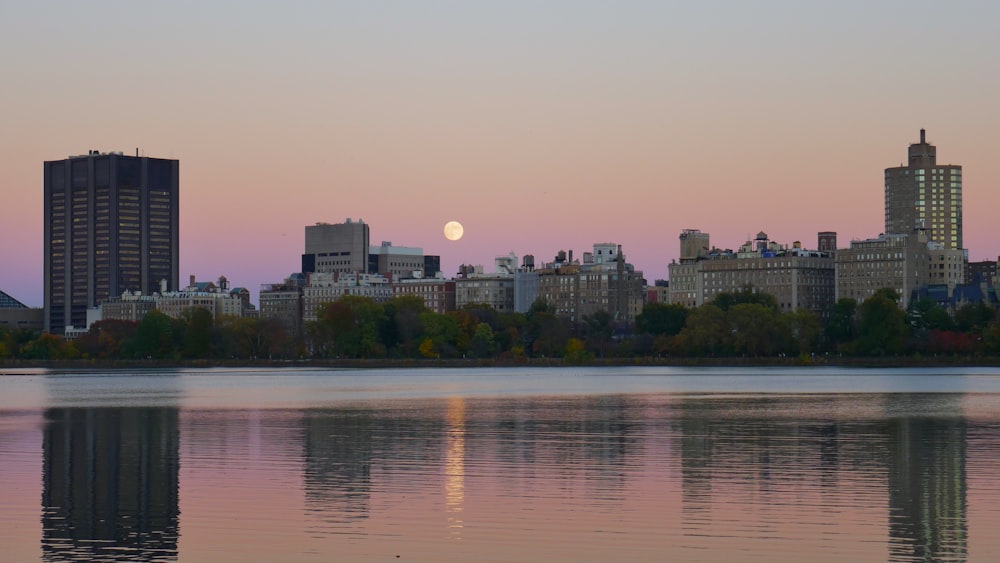 a city skyline with a full moon in the distance