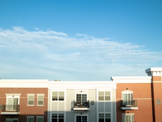 A freshly painted modern apartment building with bright, clean walls under a clear sky.