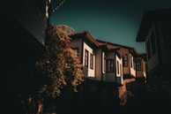 Finished Indonesian-style home with warm off-white walls and sage green accents, bathed in afternoon light.