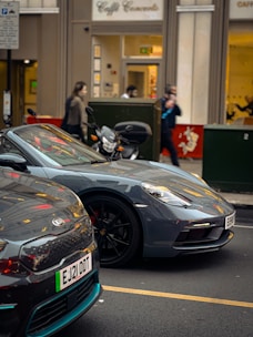 Two Mobi cars, one black and one gray, parked side by side on a city street.