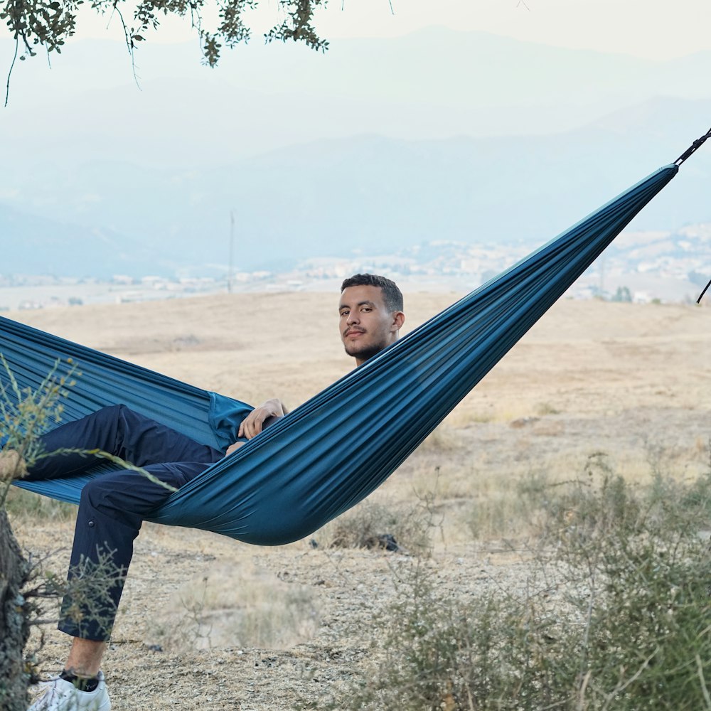 a man sitting in a hammock in a field