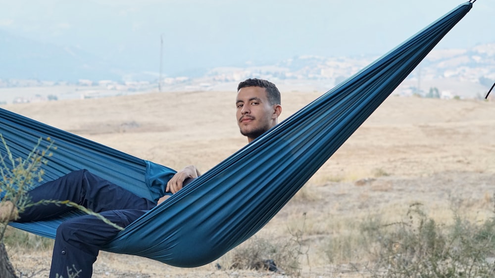 a man sitting in a hammock in a field