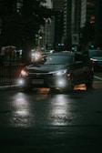 A sleek modern taxi car parked in front of a cityscape at dusk.