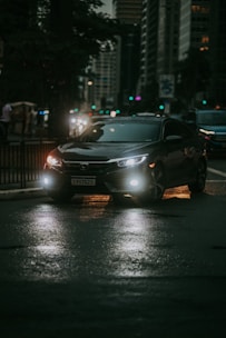 A sleek luxury car parked in front of a modern city skyline at dusk.