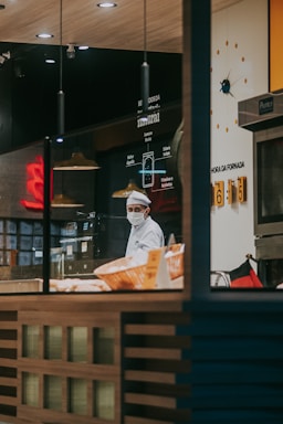a man in a chef's hat is behind the counter of a restaurant