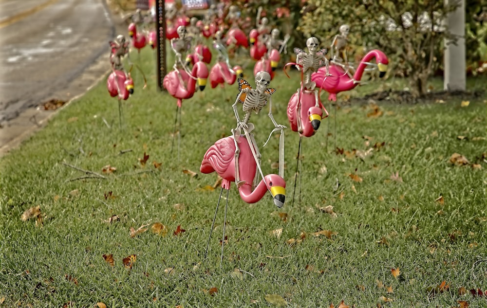a bunch of fake flamingos that are in the grass