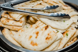 a bowl filled with pita bread and a fork