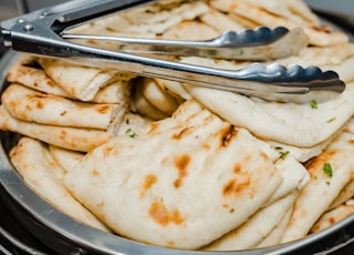 a bowl filled with pita bread and a fork