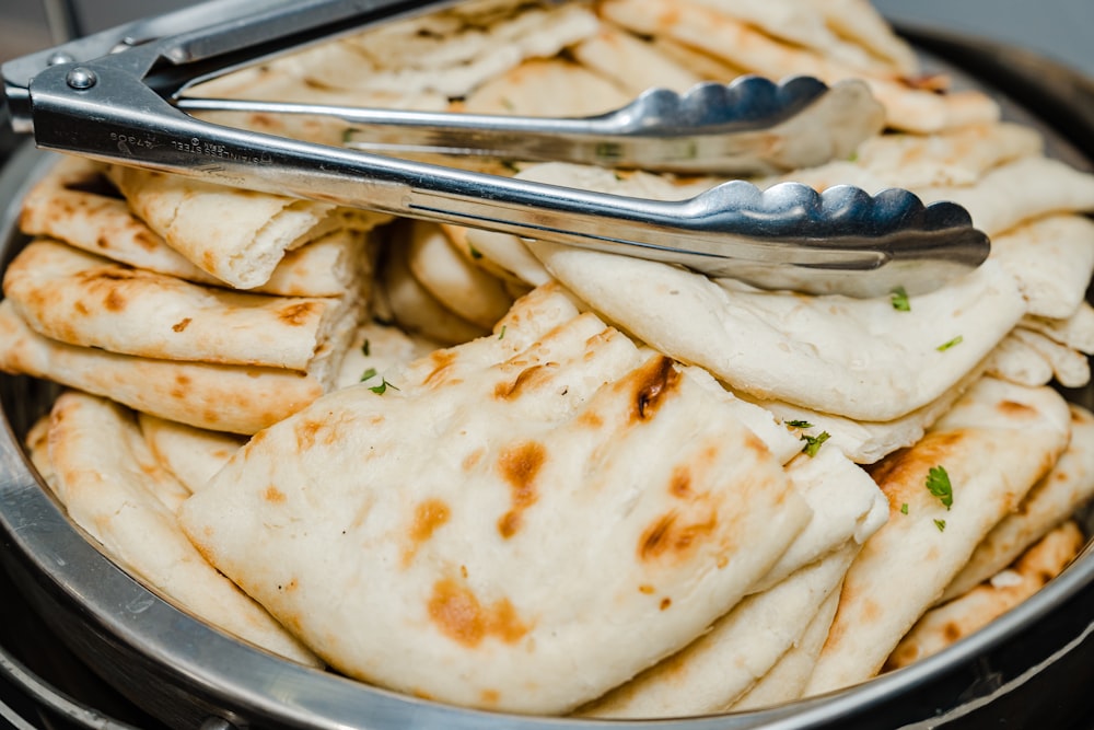 a bowl filled with pita bread and a fork