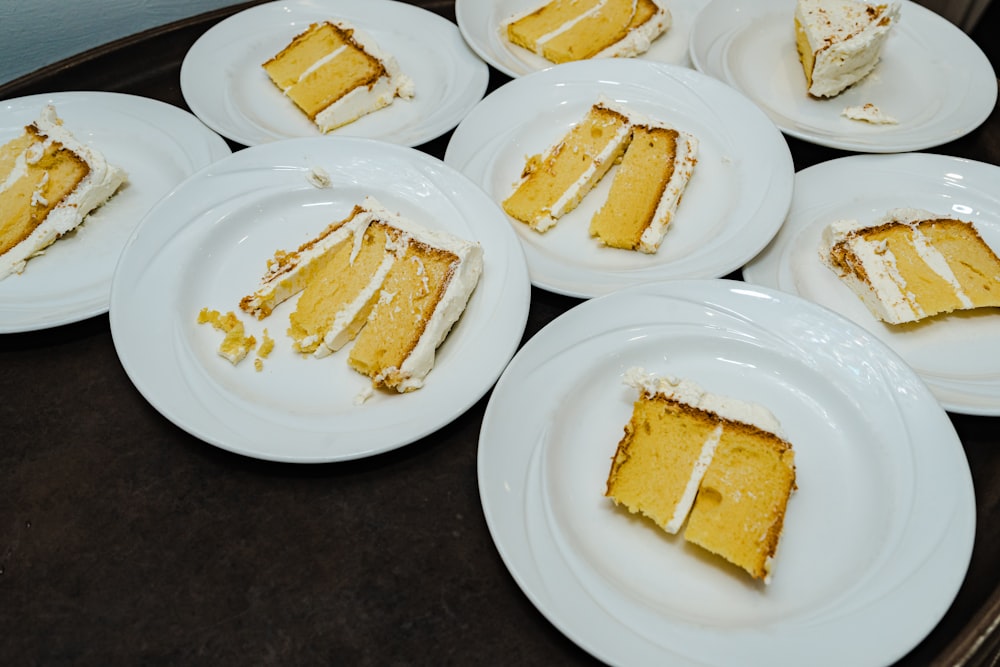 a table topped with white plates filled with slices of cake