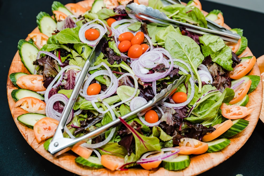 a salad with tomatoes, cucumbers, onions, lettuce and carrot