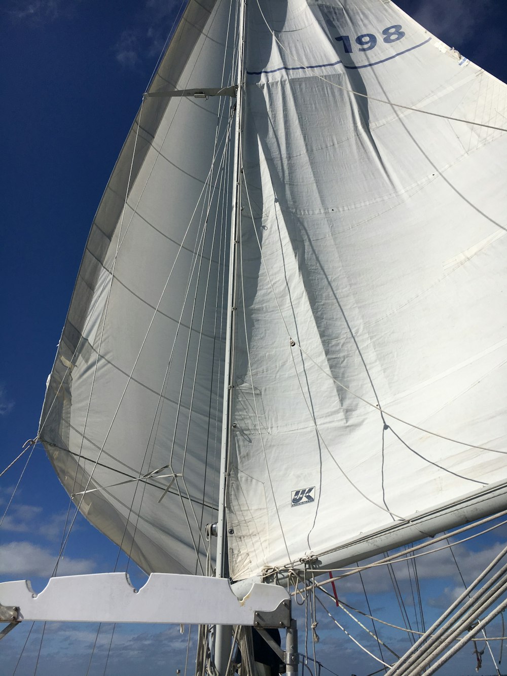 a sailboat with white sails on a sunny day