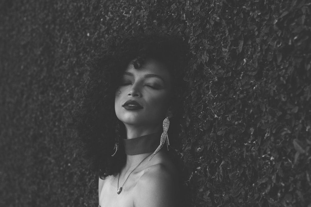 a black and white photo of a woman with her eyes closed