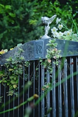 a statue of a bird on top of a fence