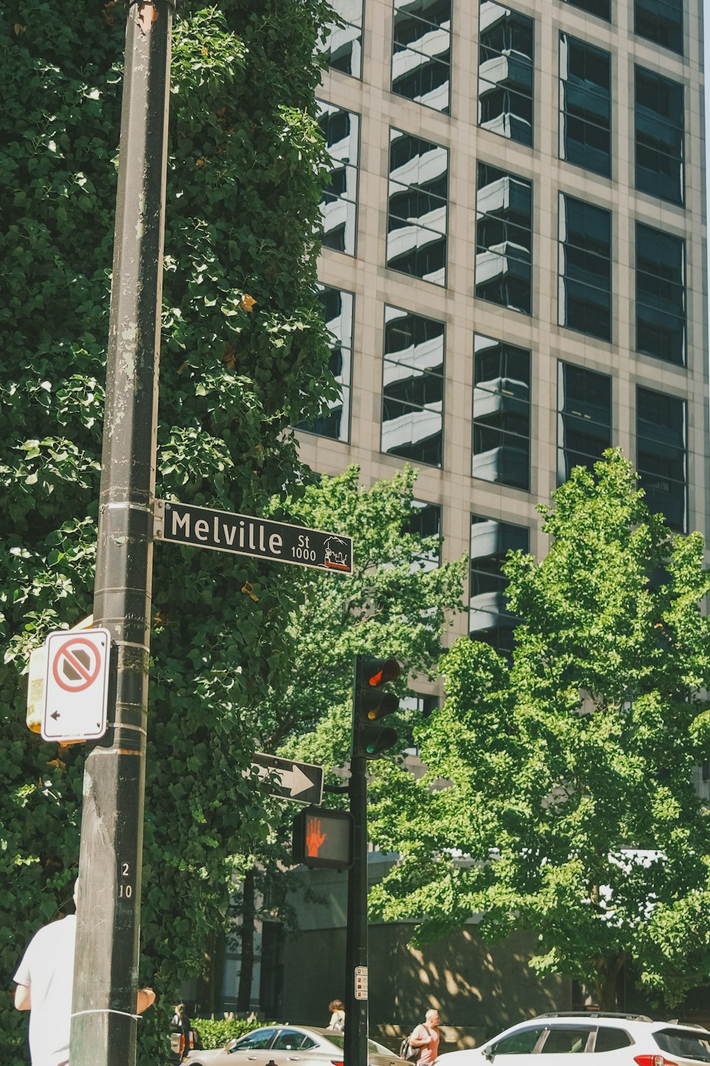 a street sign on a pole in front of a tall building