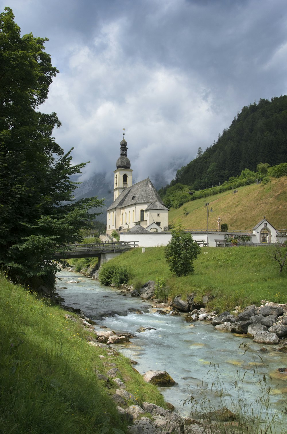 a river running through a lush green hillside