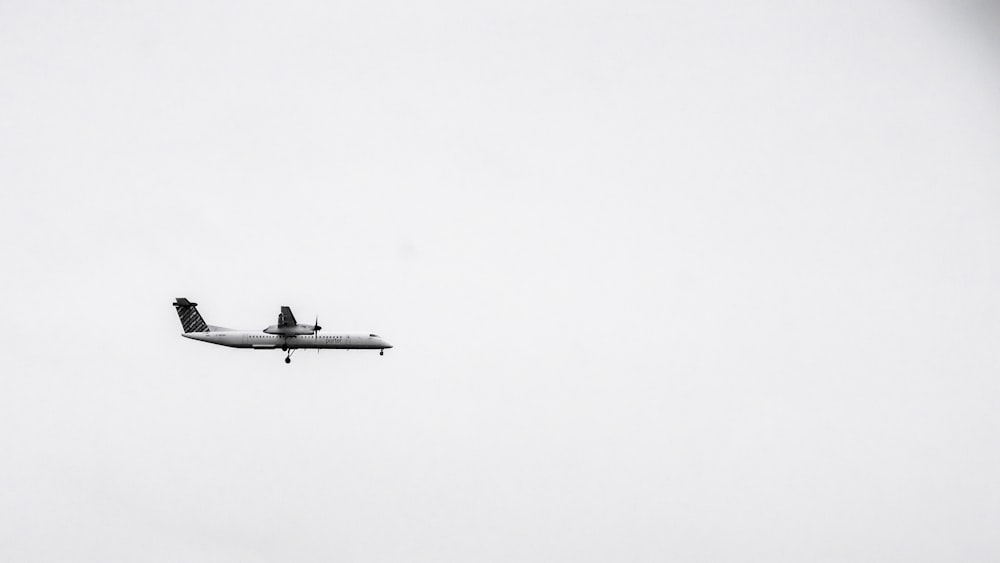 an airplane flying in the sky on a cloudy day