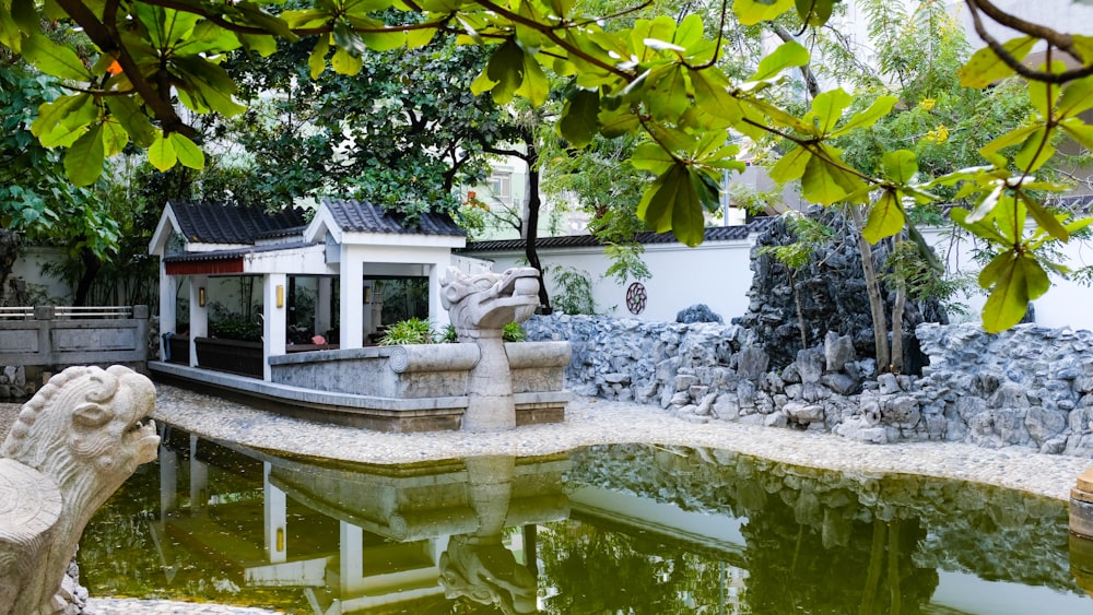 a garden with a pond and a statue