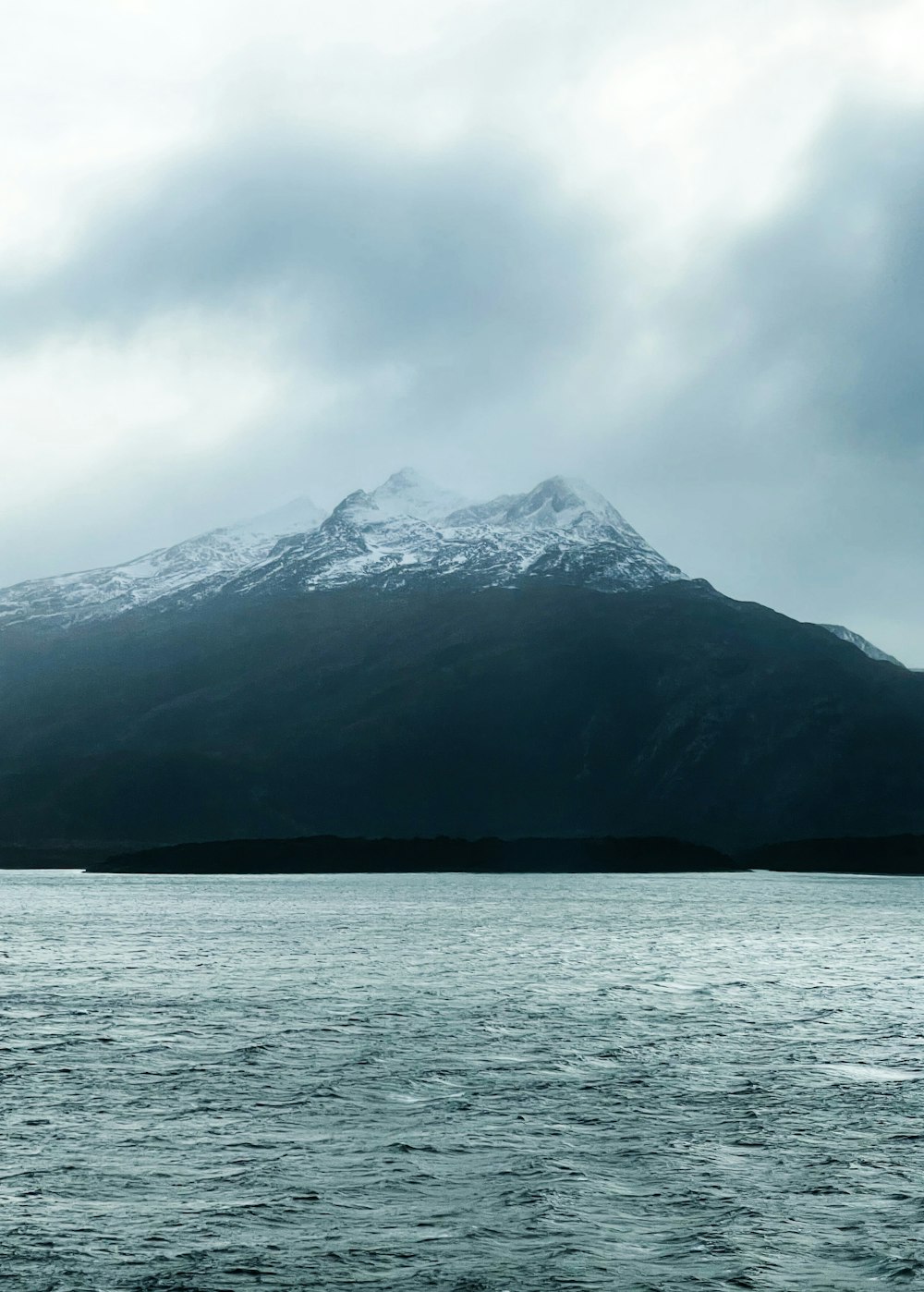 a large body of water with a mountain in the background