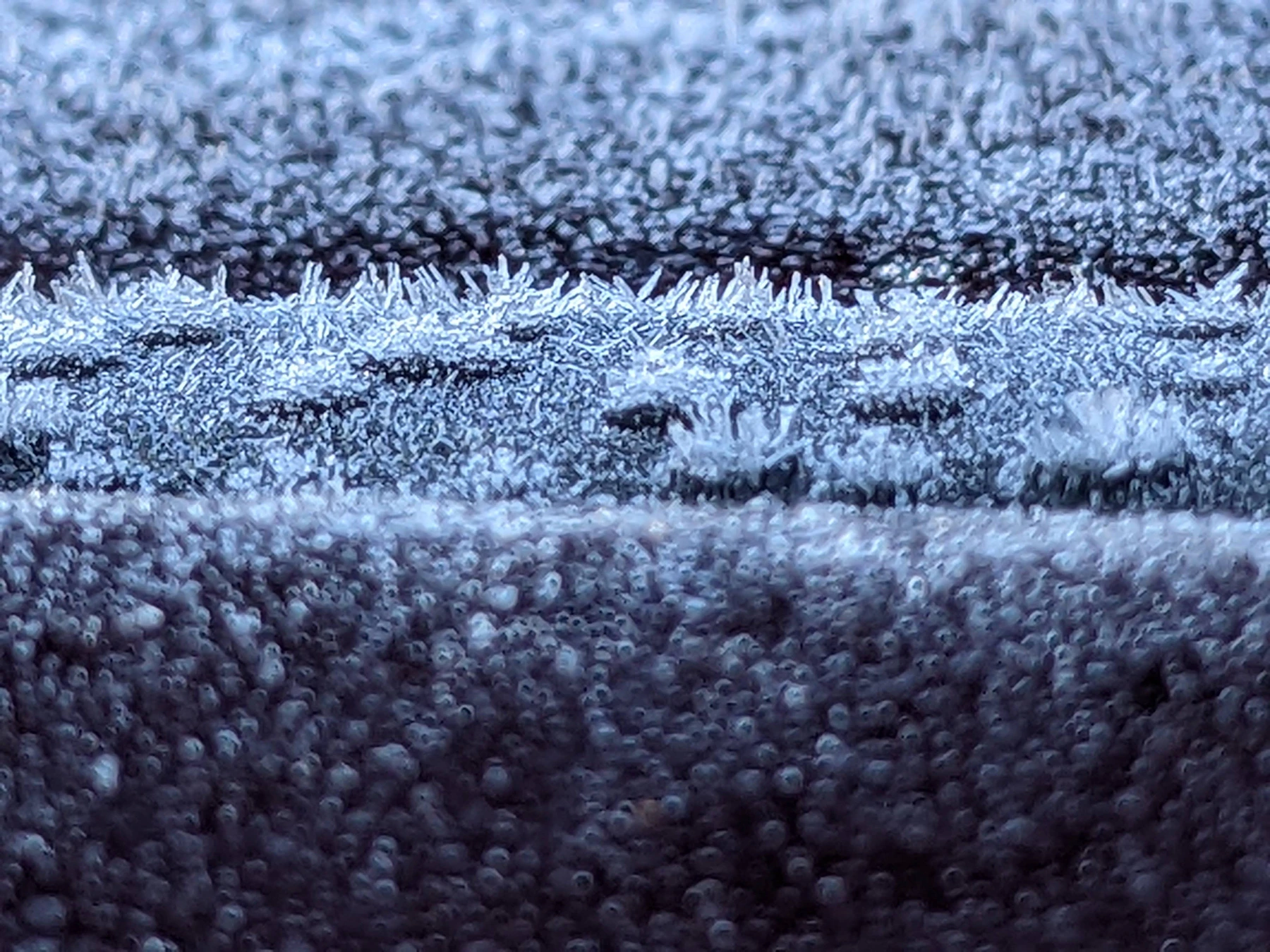 Vehicle windshield covered with winter ice and frost