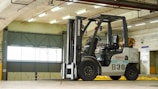 A technician inspecting a forklift in a maintenance bay.