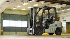 Dark blue electric forklift operating inside a modern warehouse