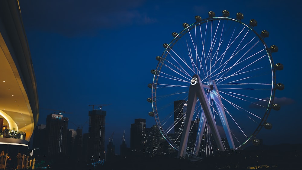 a ferris wheel in the middle of a city at night